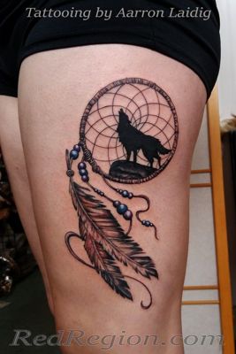  Tatouage attrape rêve avec un loup qui hurle sur la cuisse
